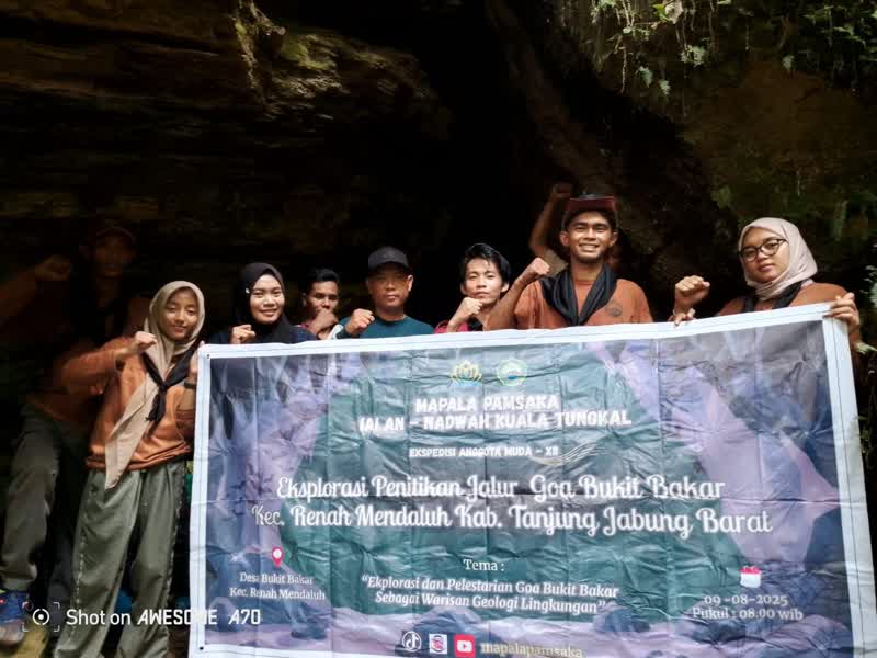 Anggota MAPALA Pamsaka IAI An-Nadwah Kuala Tungkal berpose di depan mulut Goa Bukit Bakar usai melakukan kegiatan eksplorasi jalur goa di Desa Bukit Bakar, Kecamatan Renah Mendaluh, Kabupaten Tanjung Jabung Barat.
